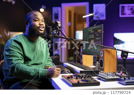 African american composer writing a new song with romantic verses, thinking of melodic elements to blend together. Artist songwriter composing a track, making rhymes with lyrics. African american composer writing a new song with romantic verses, thinking of melodic elements to blend together. Artist songwriter composing a track, making rhymes with lyrics. 117790724