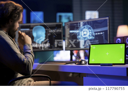 Isolated screen tablet next to sentient AI interacting with computer engineer, asking questions after modifying own source code. Chroma key device on desk next to self aware artificial intelligence Isolated screen tablet next to sentient AI interacting with computer engineer, asking questions after modifying own source code. Chroma key device on desk next to self aware artificial intelligence 117790755