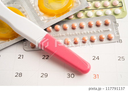 Pregnancy test and birth control pills on calendar, contraception health and medicine. Pregnancy test and birth control pills on calendar, contraception health and medicine. 117791137