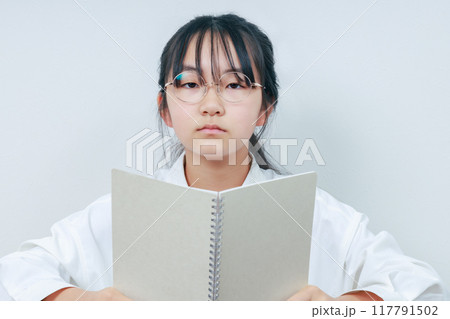 ノートを持った授業を受けている小学生 117791502