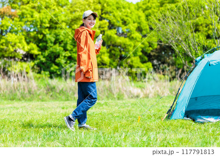 キャンプ場で水分補給する若い女性 キャンプ場で水分補給する若い女性 117791813