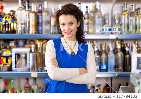Woman works as salesperson in alcohol department of Russian store. 117794132