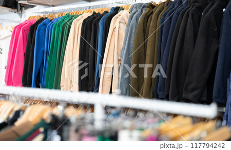 Women's clothing hanging on rack in store 117794242