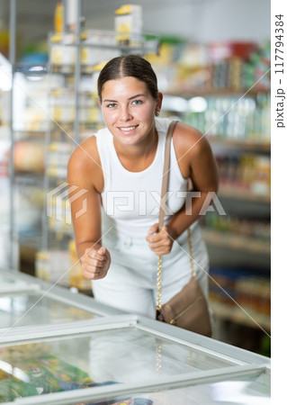Young woman choosing frozen food in store 117794384