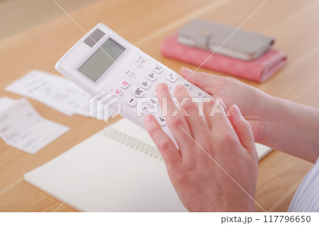 電卓でお金の計算をするミドル女性 電卓でお金の計算をするミドル女性 117796650