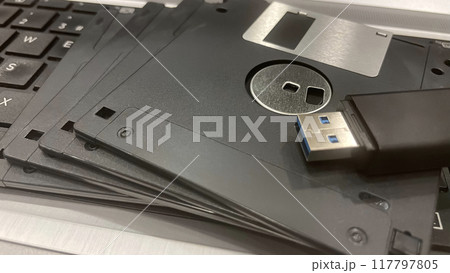 From Past to Present. The Evolution of Data Storage. The striking visual comparison between an old black floppy disk and today's blue USB stick symbolizes the rapid advancement of data storage technol From Past to Present. The Evolution of Data Storage. The striking visual comparison between an old black floppy disk and today's blue USB stick symbolizes the rapid advancement of data storage technol 117797805