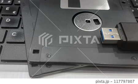 From Past to Present. The Evolution of Data Storage. The striking visual comparison between an old black floppy disk and today's blue USB stick symbolizes the rapid advancement of data storage technol From Past to Present. The Evolution of Data Storage. The striking visual comparison between an old black floppy disk and today's blue USB stick symbolizes the rapid advancement of data storage technol 117797807