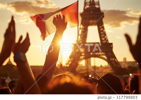 Crowd holding a flag with the Eiffel Tower at sunset in the background. High quality photo 117799803