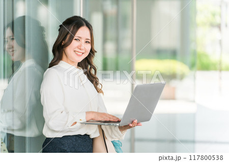 ビジネス街でノートパソコンを使うオフィスカジュアルのOL・ビジネスウーマン 117800538