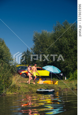 Couple Enjoying a Summer Day by the Lake 117803996