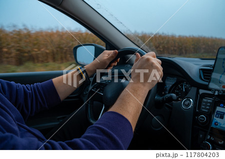 Person Driving by the road at foggy autumn highway 117804203