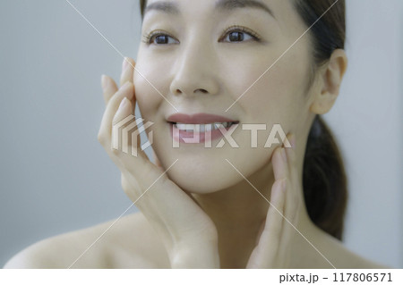 お肌のお手入れをする若い女性 117806571