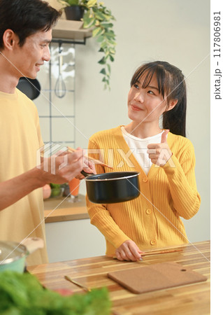Young couple sharing a bowl of instant noodles, enjoying a casual meal in kitchen 117806981