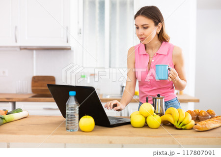 Woman cooking salad recipe from the Internet Woman cooking salad recipe from the Internet 117807091