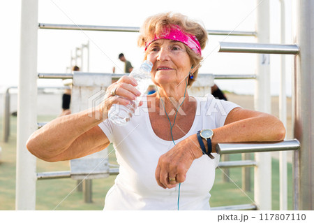 Old lady in outdoor workout station 117807110
