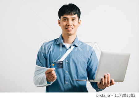 Despite a broken arm, Portrait Asian young man wearing a cast on his arm broken studio shot isolated white background, men using splint for treatment and show credit card for payment before work 117808382