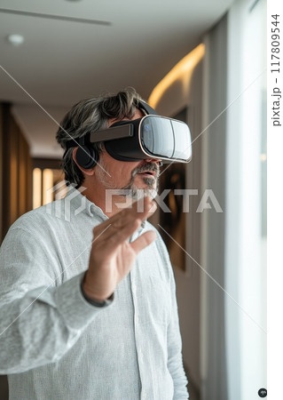 Mature Man Experiencing Virtual Reality with VR Headset in Modern Home Environment 117809544