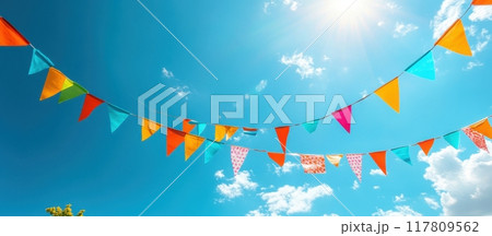 Colorful Festive Bunting Flags Against a Clear Blue Sky on a Sunny Day 117809562