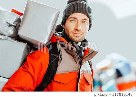 Confident young delivery man carrying cardboard boxes. Confident young delivery man carrying cardboard boxes. 117810149