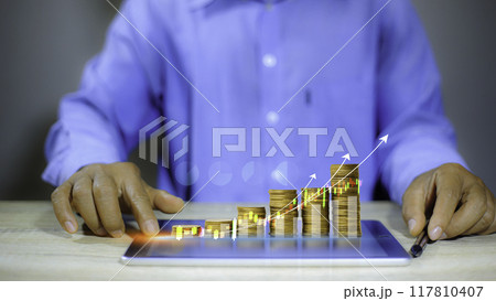 Business putting gold coins in piles of gold saving money for future and retirement concept. Save money with stack coin for growing your business investment concept. Savings money concept.. 117810407