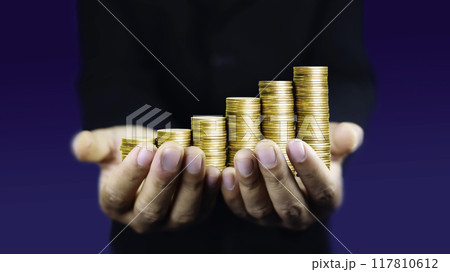 Businessman put gold coins on hand. business growth concept of success in investing business in wealth stocks technology grow. Money saving. Gold coins chart an increase inflation. 117810612