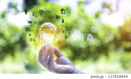 green energy concept help reduce global warming..Hand holding natural background light bulb on green leaf with clean energy icon around it. Carbon dioxide emission in industry zero carbon concept.. green energy concept help reduce global warming..Hand holding natural background light bulb on green leaf with clean energy icon around it. Carbon dioxide emission in industry zero carbon concept.. 117810644