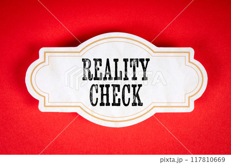 Reality Check. Cardboard sticker with text on a red background Reality Check. Cardboard sticker with text on a red background 117810669