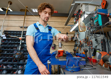 Cropped shot of craftsman using antique bench vise in repair shop Cropped shot of craftsman using antique bench vise in repair shop 117811549