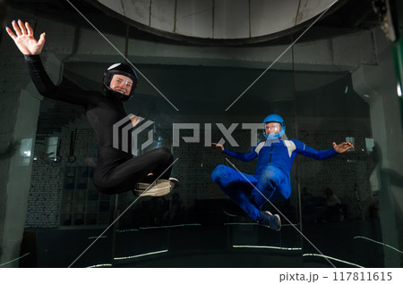 A man and a woman enjoy flying together in a wind tunnel. Free fall simulator 117811615