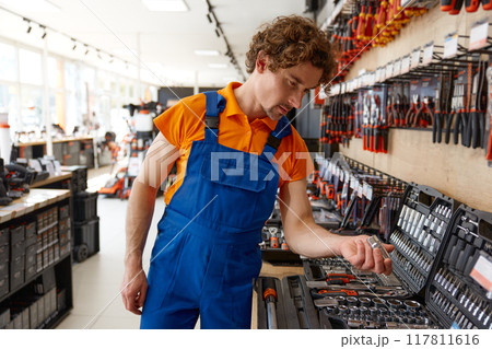 Salesman checking socket wrenches in tool box at hardware store 117811616