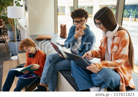 Group of teenagers in coworking office making money online Group of teenagers in coworking office making money online 117811823