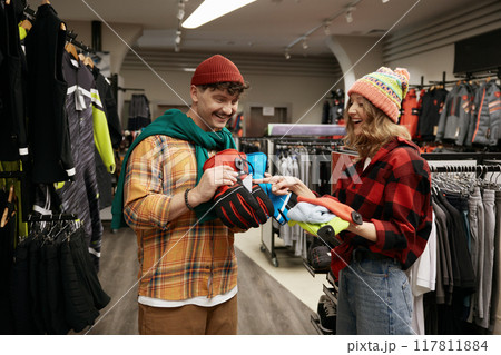 Young man and woman shopping sports gear for bicycle tour in winter Young man and woman shopping sports gear for bicycle tour in winter 117811884
