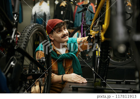 Hipster man selecting new mountain bike in shop 117811913