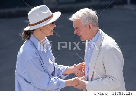Stylish elderly laughing couple on a walk. Romantic relationships of mature people.  117812128