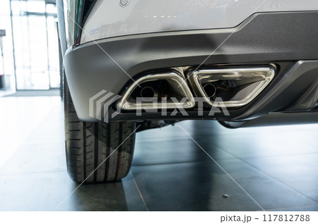 Double exhaust pipe in a new car in a car showroom.  117812788