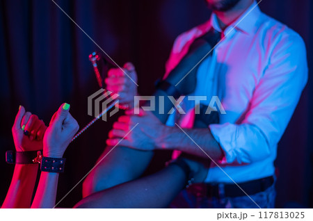 Sensual couple during role play. A man holds a woman by handcuffs. BDSM concept. Sensual couple during role play. A man holds a woman by handcuffs. BDSM concept. 117813025