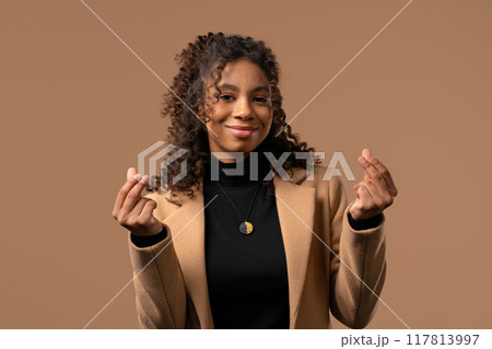 Young african teen girl, money gesture on studio background. Smart lady smiles 117813997