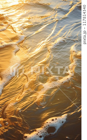 Beautiful gold wave in the ocean. Water surface in the golden light of the sun at sunset or dawn. Surfer's POV Beautiful gold wave in the ocean. Water surface in the golden light of the sun at sunset or dawn. Surfer's POV 117814340