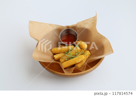 Breaded mozzarella cheese sticks with ketchup or bbq sauce in wooden plate 117814574