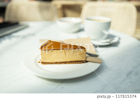 Tasty cheesecake with caramel and nuts served on white table. Classic New York cheesecake on a white concrete background, side view.  117815374