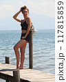 Casual summer look at the lake: woman on a jetty in black lace 117815859