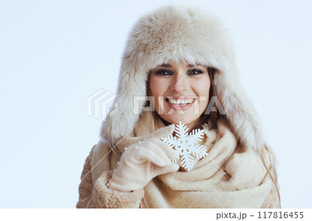smiling stylish woman in winter coat and fur hat on white 117816455