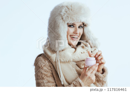 happy stylish woman in winter coat and fur hat on white 117816461