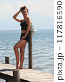 Casual summer look at the lake: woman on a jetty in black lace 117816590