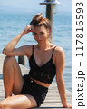 Relaxed summer portrait: Woman in a black lace top by the lake 117816593