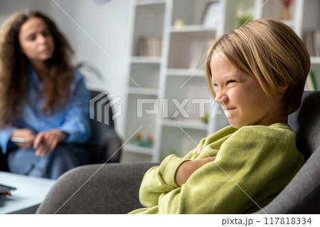 Blonde boy looking upset and unhappy during speech therapy 117818334