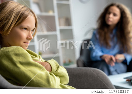 Blonde boy looking upset and unhappy during speech therapy 117818337