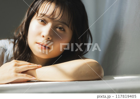 西陽の窓辺の女性 117819405