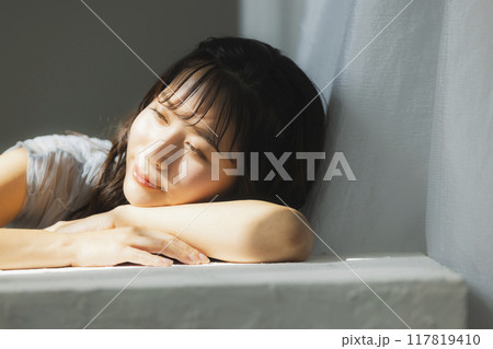 西陽の窓辺の女性 117819410