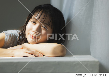 西陽の窓辺の女性 117819411